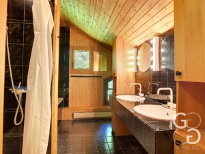 Une salle de bain avec deux vasques et une douche.