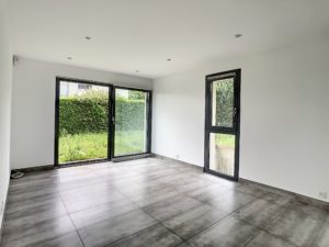 Une pièce avec une porte coulissante en verre et du carrelage au sol.