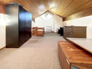 Une chambre avec un plafond en bois et un bureau.