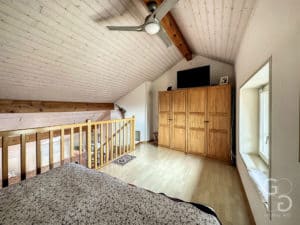Une chambre avec plafonds en bois et ventilateur.