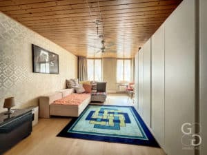 Un salon avec des plafonds en bois et un tapis.