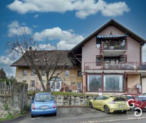 Deux voitures garées devant une maison.