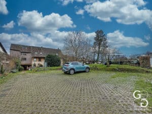 Une maison avec une voiture garée devant.