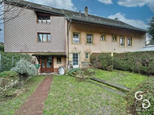 Une maison avec une cour et de l'herbe.