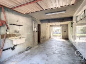 Un couloir vide avec un lavabo et des toilettes.