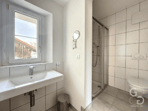 Une salle de bain avec un lavabo et une fenêtre.