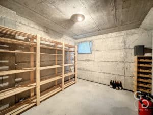 Une cave à vin avec étagères en bois et bouteilles de vin.