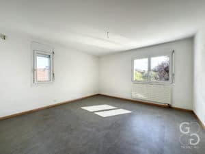 Une pièce vide avec une fenêtre et un radiateur.