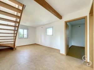 Une pièce avec un escalier en bois et un parquet en bois.
