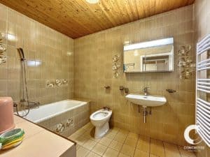 Une salle de bain carrelée avec WC et lavabo.