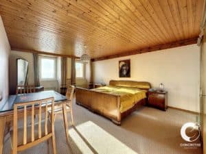 Une chambre avec plafonds en bois et un lit.