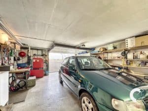 Une voiture verte est garée dans un garage.