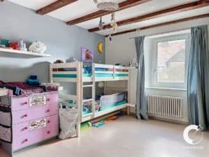 Une chambre enfant avec un lit superposé et une commode.