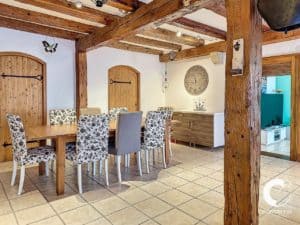 Une salle à manger avec poutres en bois et table en bois.