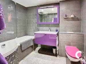 Une salle de bain aux accents violets et gris.