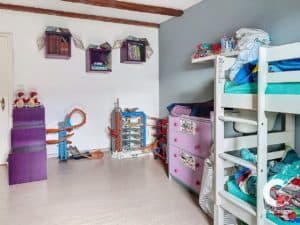 Une chambre d'enfant avec un lit superposé et des jouets.