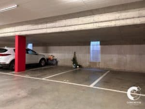 Un parking couvert avec une voiture garée à l'intérieur.