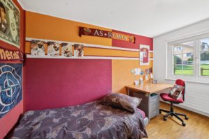 Une chambre aux couleurs vives avec des décorations sur le thème du football et un espace de travail.