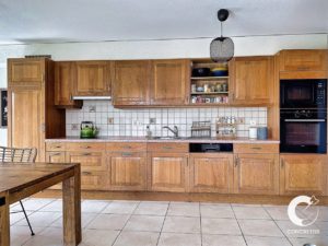 Une cuisine lumineuse et bien rangée avec des armoires en bois et des appareils modernes.